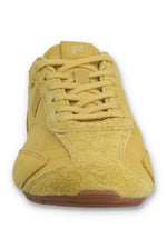 Front view of a FILA Ritmo trainer in yellow suede, showcasing the textured toe box, matching yellow laces, and an embossed FILA 'F' logo on the tongue against a white background.