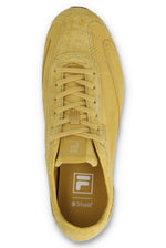 Overhead view of a FILA Ritmo trainer in yellow suede, showing the lacing system, tongue branding, and a branded brown OrthoLite insole against a white background.