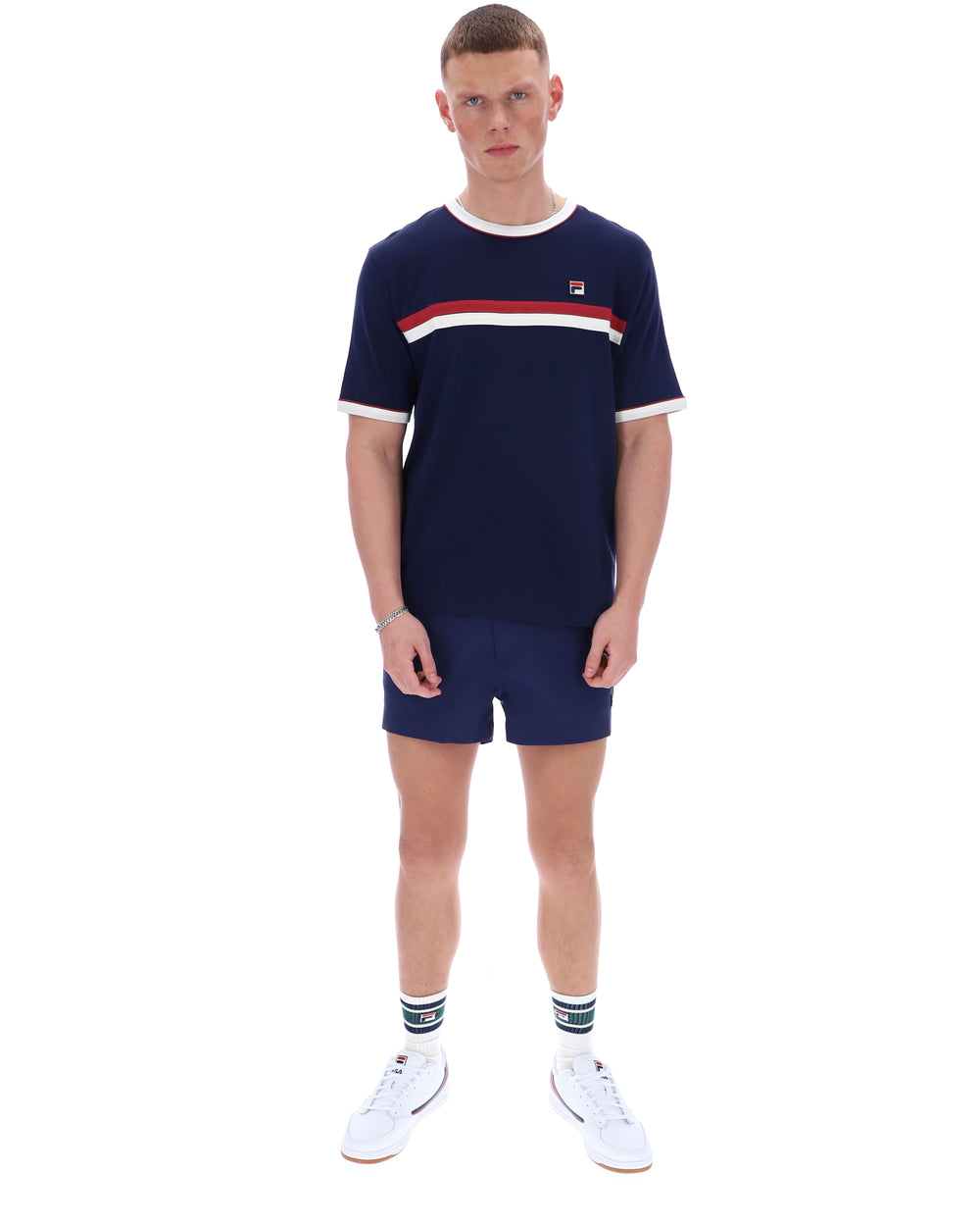 Man wearing a navy blue t-shirt with a red and white stripe and matching shorts on a white background