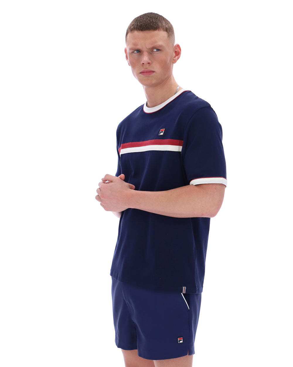Man wearing a navy blue sports outfit with a red and white stripe on a white background