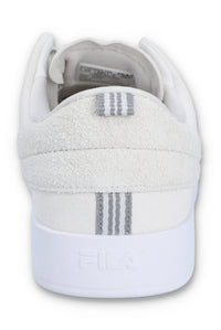 A white suede tennis trainer with low-top design and lace-up closure.
