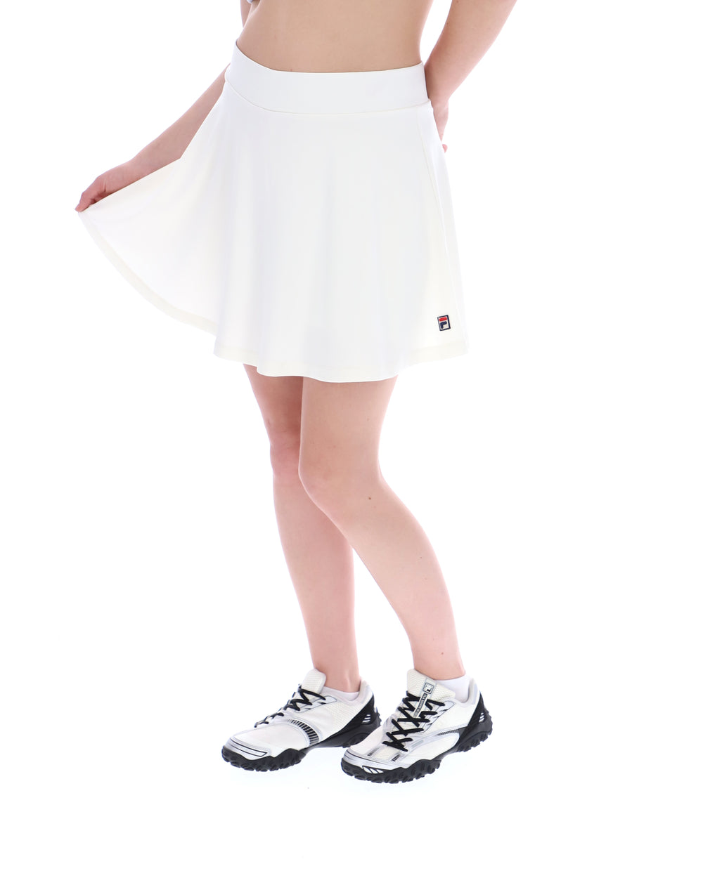 Person wearing a white tennis skirt with a brand logo on a white background