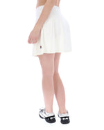 Person wearing a white skirt and black and white shoes on a white background