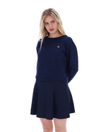 Woman wearing a navy blue outfit with a logo on a white background