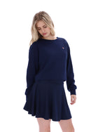 Woman wearing a navy blue outfit with a small logo on a white background