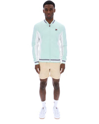 Man wearing a light blue jacket with white accents and beige shorts on a white background