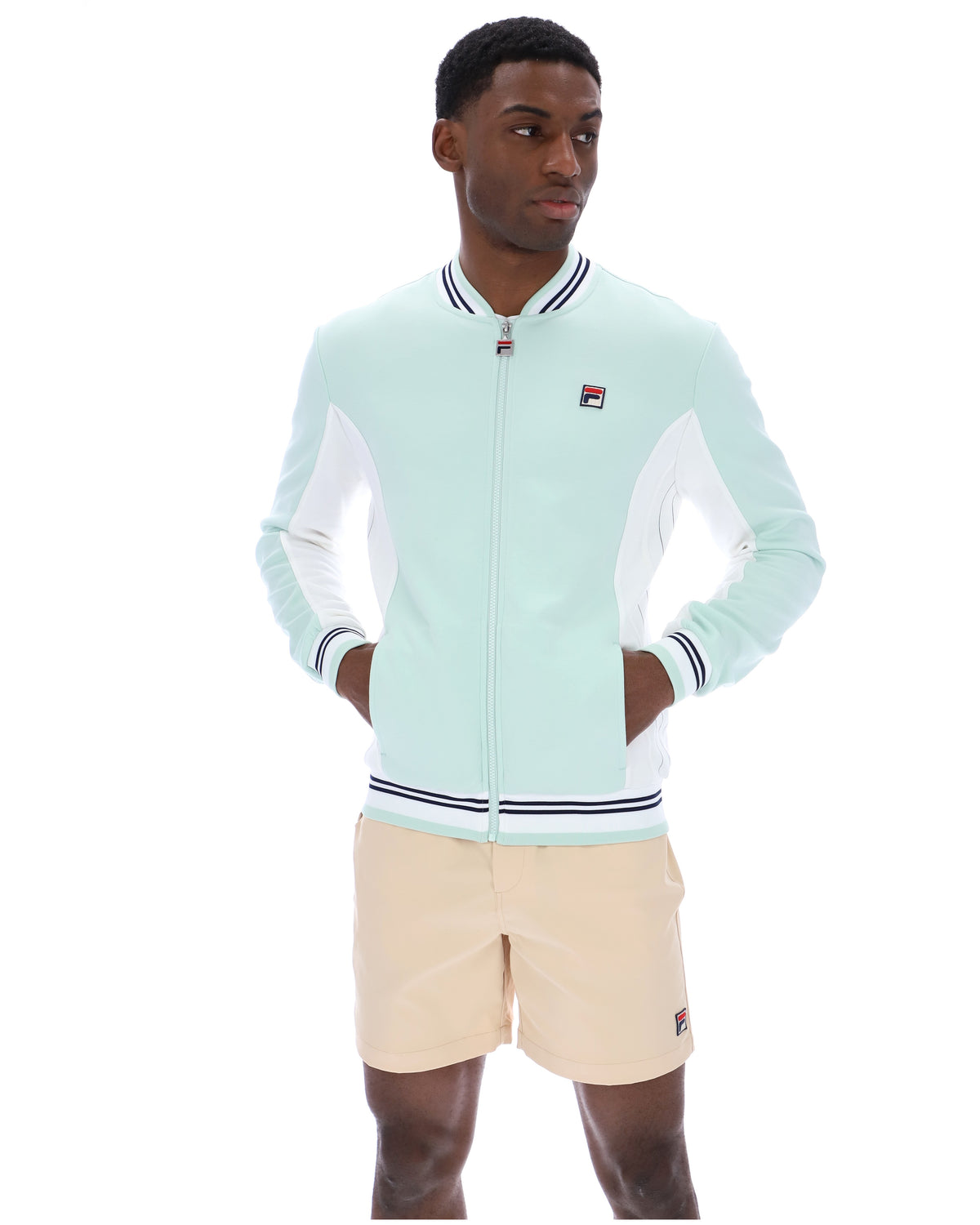 Man wearing a light blue tracksuit with a white background