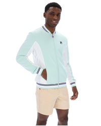 Man wearing a light blue jacket with white accents and beige shorts on a white background