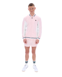 Person wearing a pink tracksuit with a FILA logo, paired with matching shorts on a white background