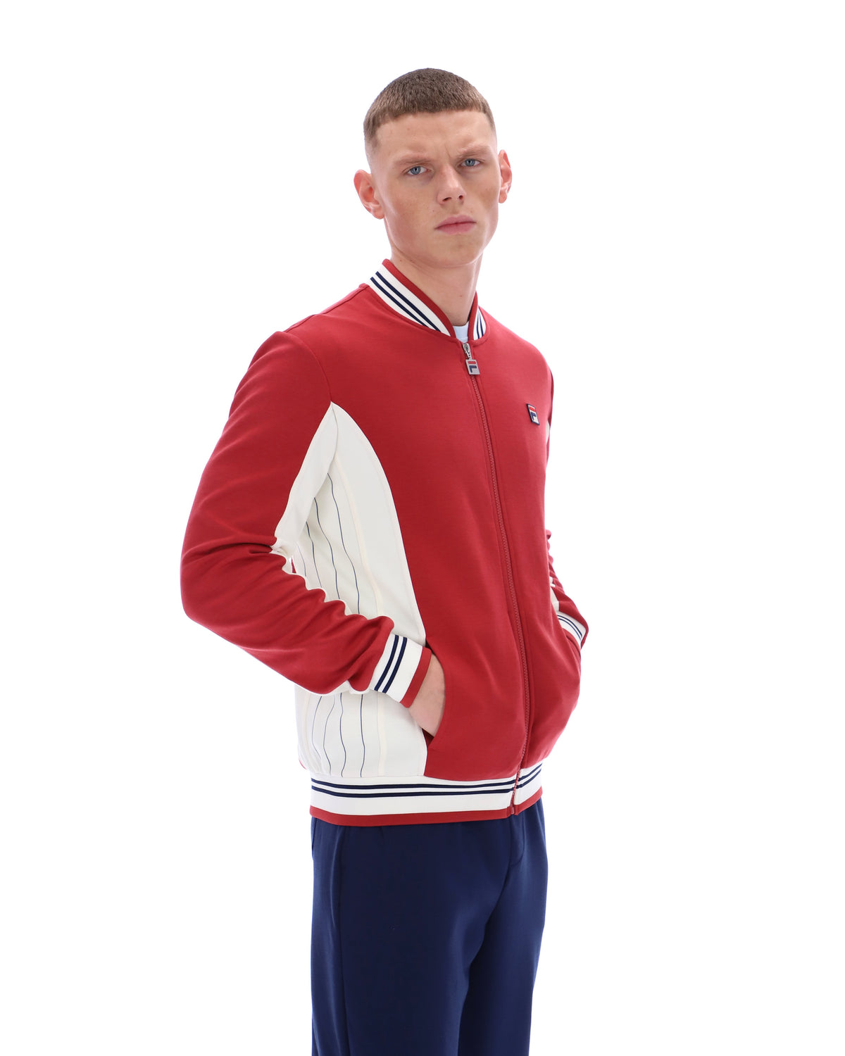 Man wearing a red and white jacket with blue pants on a white background