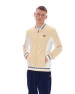 Man wearing a beige and white jacket with navy pants on a white background