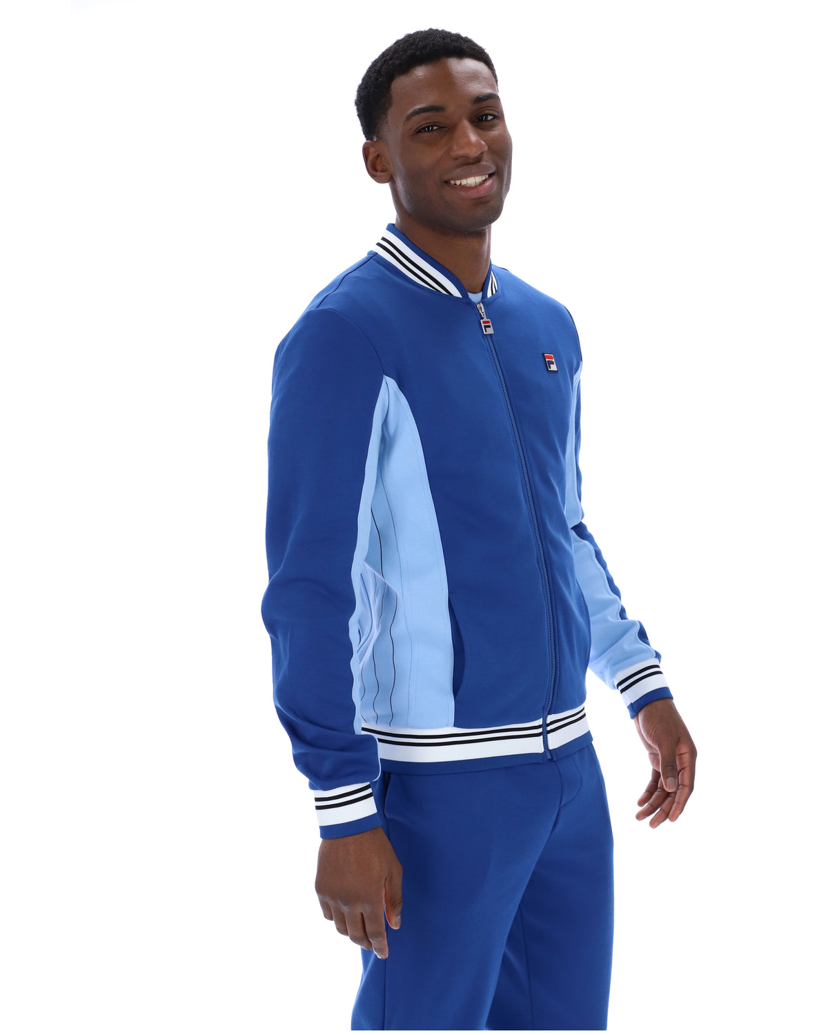 Man wearing a blue tracksuit with a light blue panel on a white background