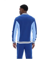 Man wearing a blue tracksuit with light blue sleeves on a white background