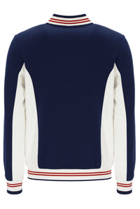 Navy and white sweater with red and white striped trim on a white background