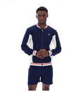 Man wearing a navy tracksuit with white accents on a white background