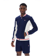 Man wearing a navy tracksuit Jacket and shorts with white accents on a white background