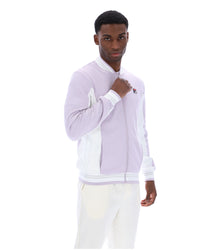 Displays a model wearing the Misty Lilac 'FILA' branded Settanta Baseball Track Top