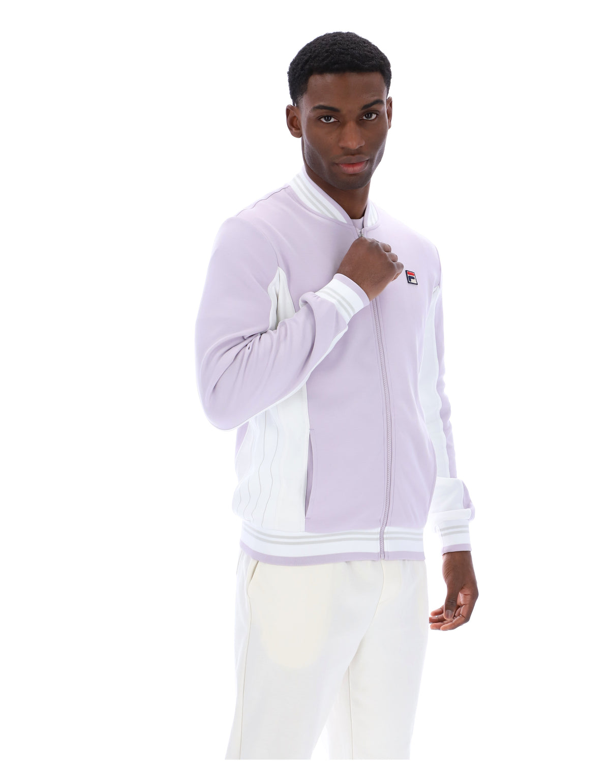 Displays a model wearing the Misty Lilac 'FILA' branded Settanta Baseball Track Top