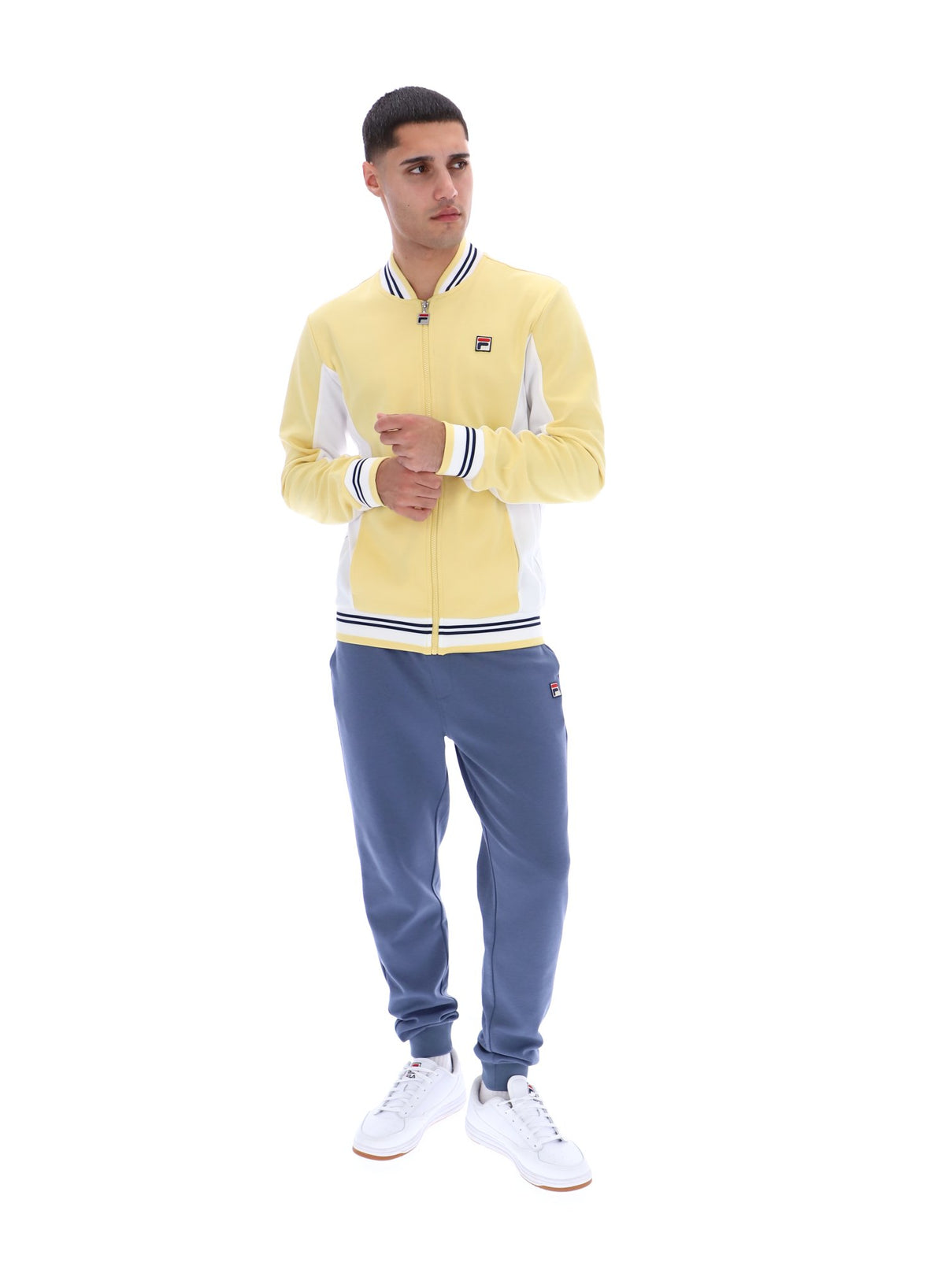 Man wearing a yellow tracksuit with a brand logo on a white background
