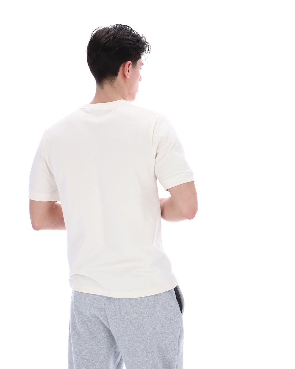 Man wearing a white t-shirt and grey bottoms on a white background