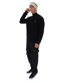 Displays a model wearing the Black 'FILA' branded Stevie 1/4 Zip Funnel Neck Textured Knit