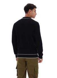 Person wearing a black jacket with white trim on a white background