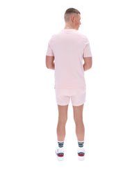 Person wearing a light pink outfit with white shoes on a white background