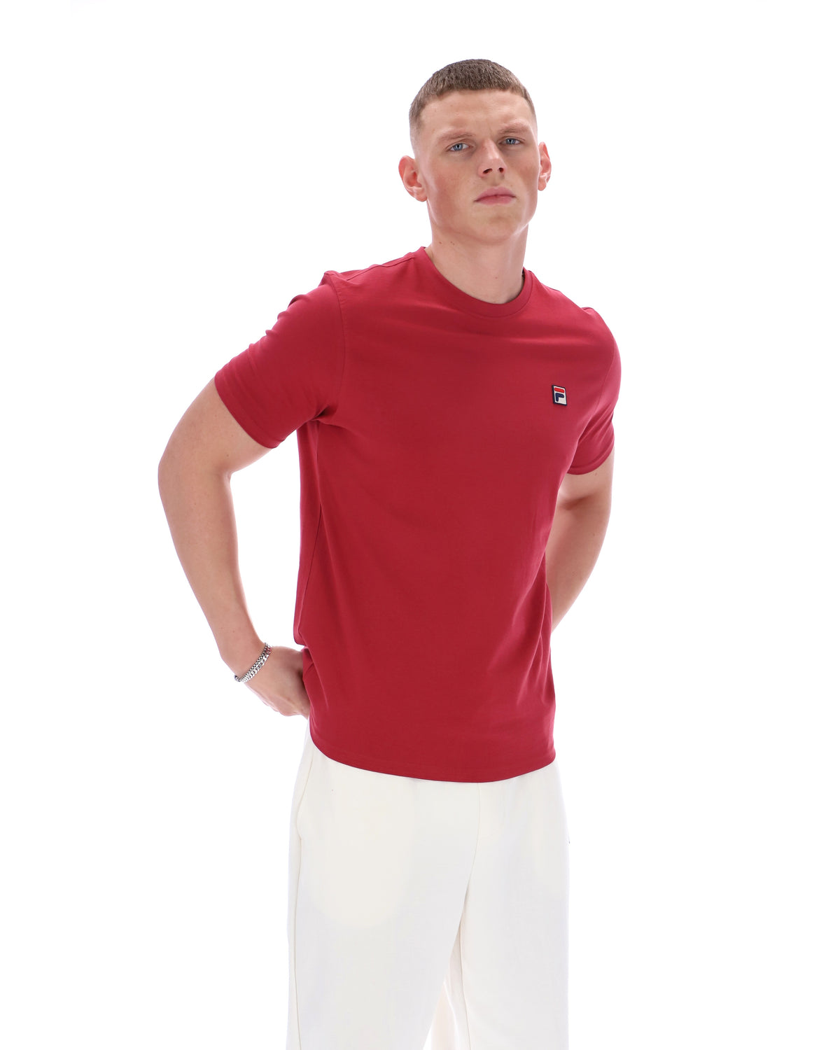 Man wearing a red t-shirt with a small logo on a white background