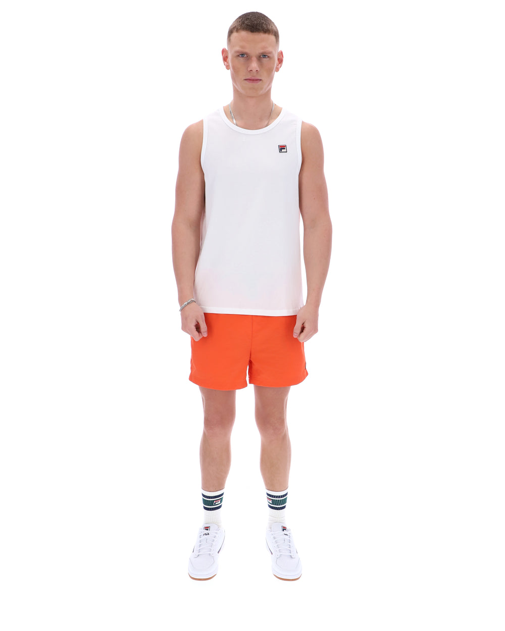 Person wearing a white tank top and orange shorts on a white background