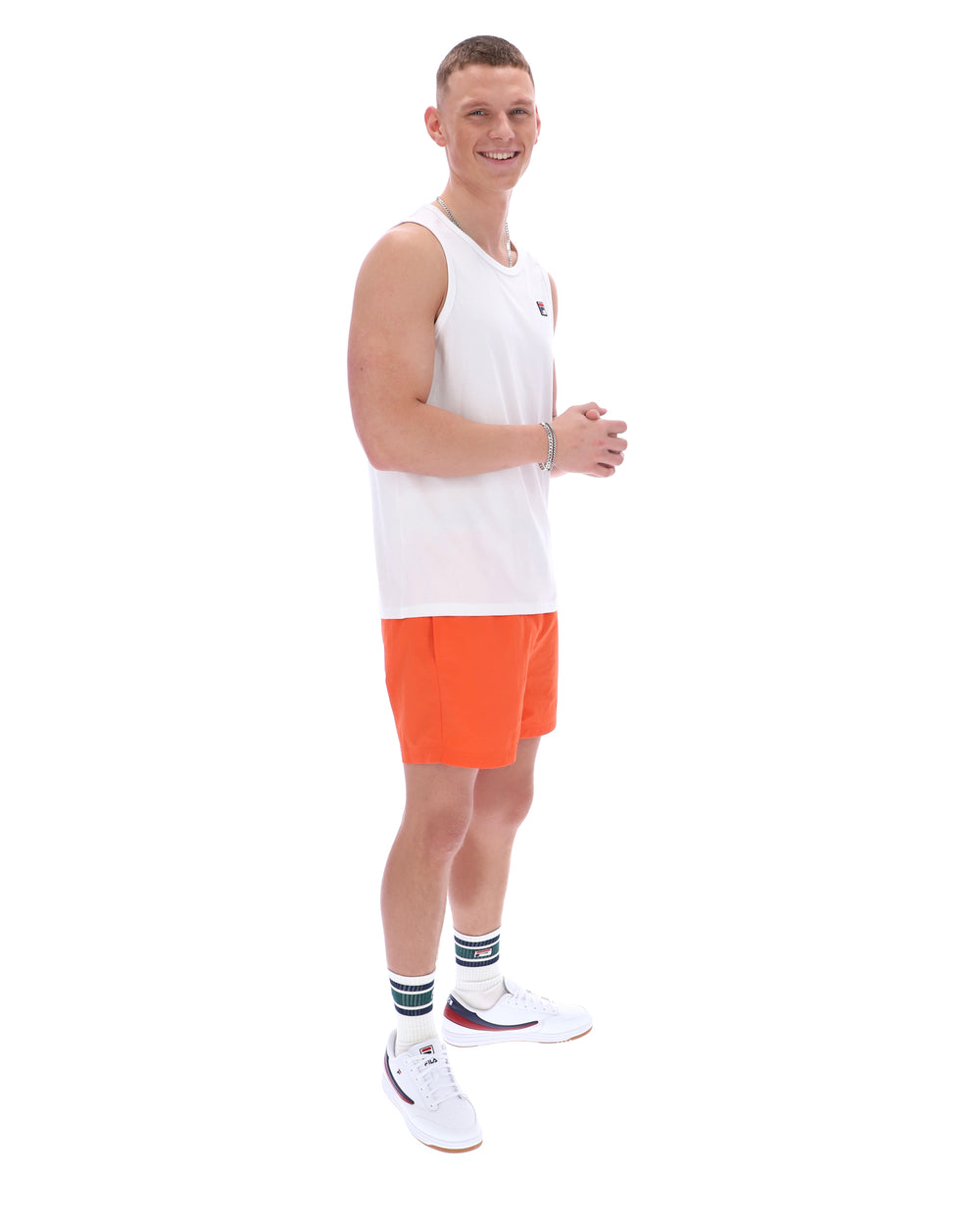 Man wearing a white tank top and orange shorts on a white background