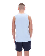 Person wearing a light blue sleeveless shirt and navy shorts on a white background