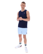 Man wearing a navy sleeveless shirt and light blue shorts on a white background