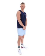 Man wearing a navy sleeveless shirt and light blue shorts on a white background