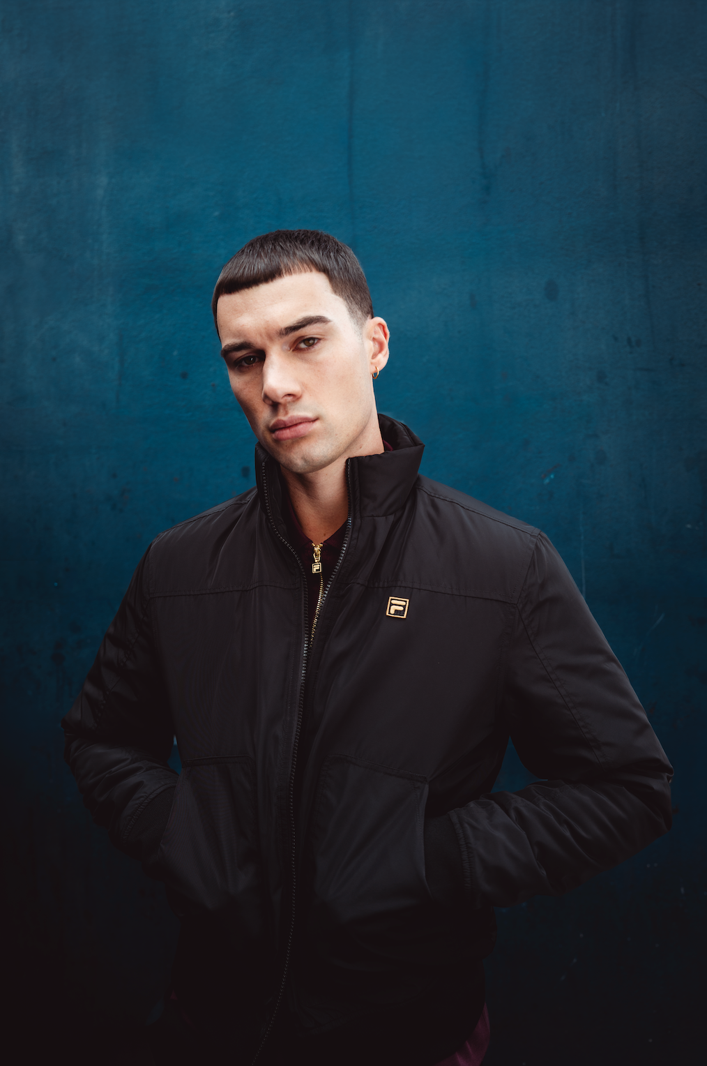 Displays a model wearing the Black 'FILA' branded Etton Bomber Jacket
