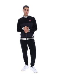 Person wearing a black tracksuit with white accents and FILA logo on a white background