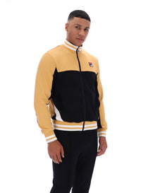 Man wearing a black and beige tracksuit with a FILA logo on the chest, paired with black FILA bottoms, against a white background
