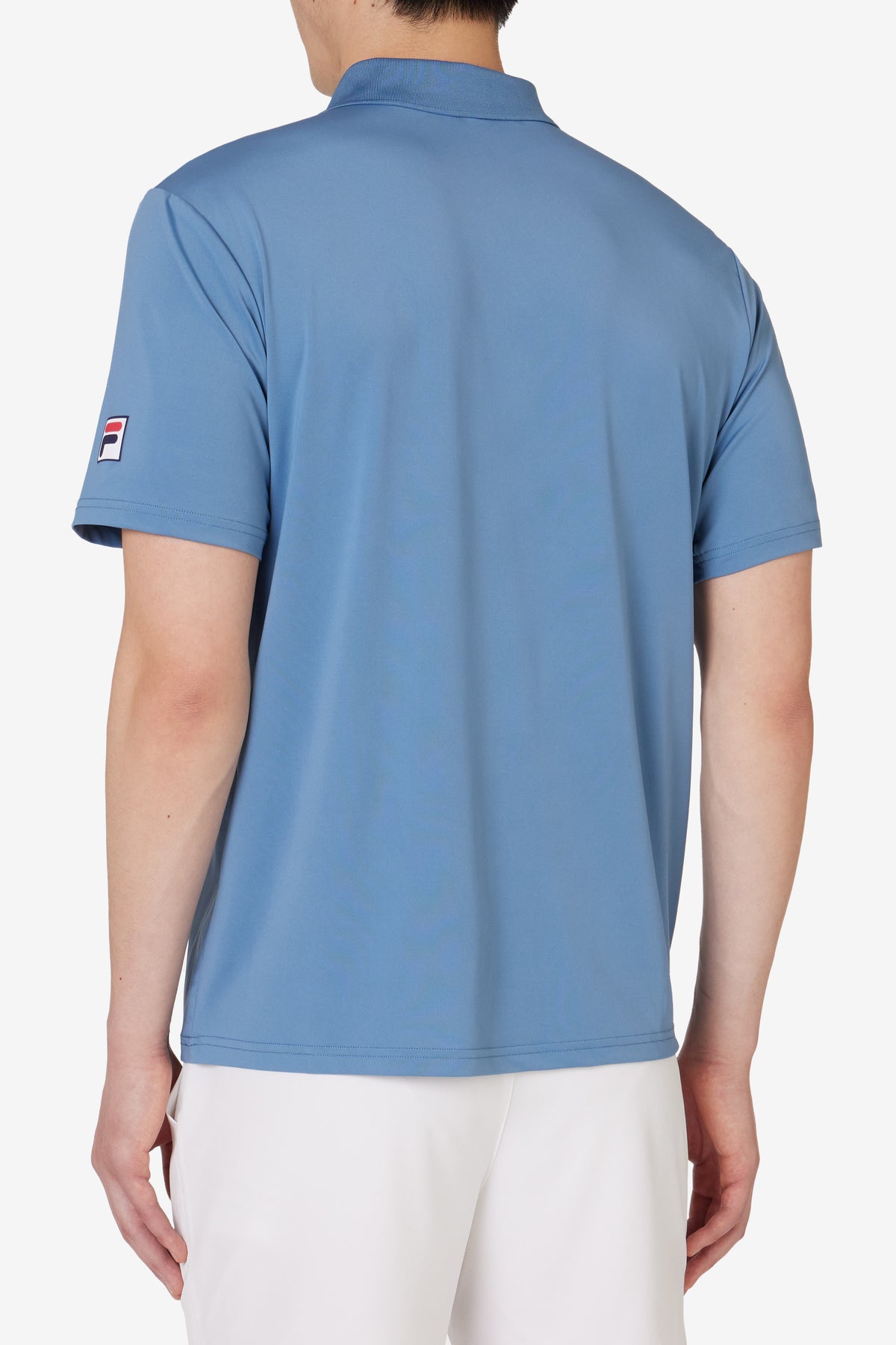 Displays a model wearing the Blue 'FILA' branded Tennis Essentials Top