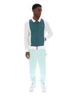 Man wearing a teal and white jacket with matching pants on a white background