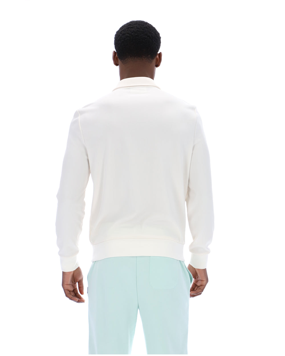 Person wearing a white sweater and light blue pants on a white background