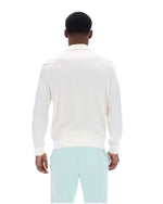 Person wearing a white sweater and light blue pants on a white background