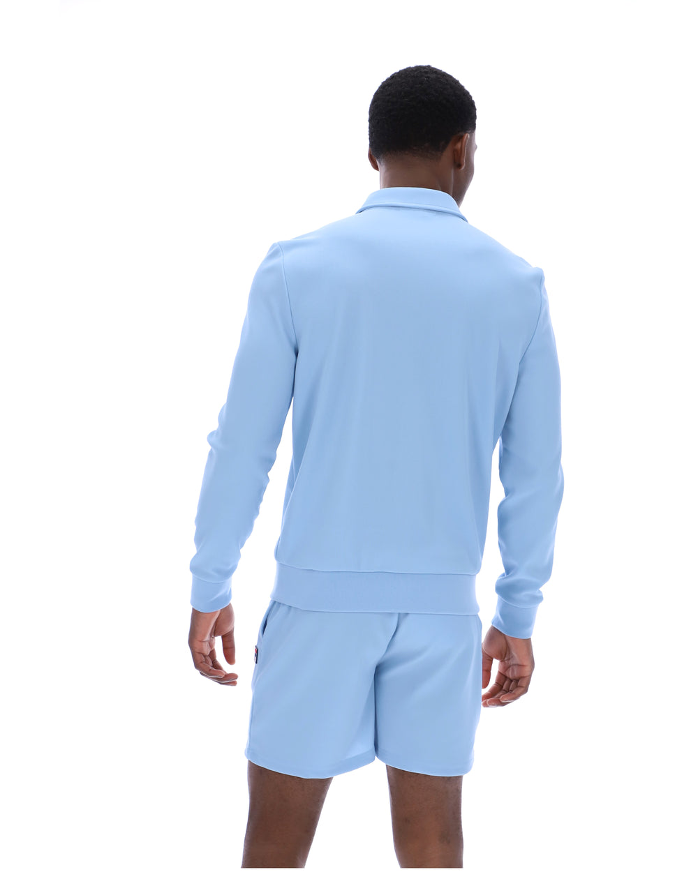 Person wearing a light blue long-sleeve shirt and shorts set on a white background