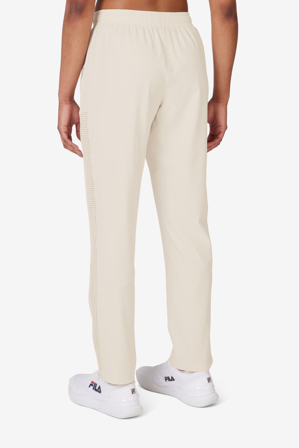 Displays a model wearing the Beige 'FILA' branded Tennis Advantage Track Pant