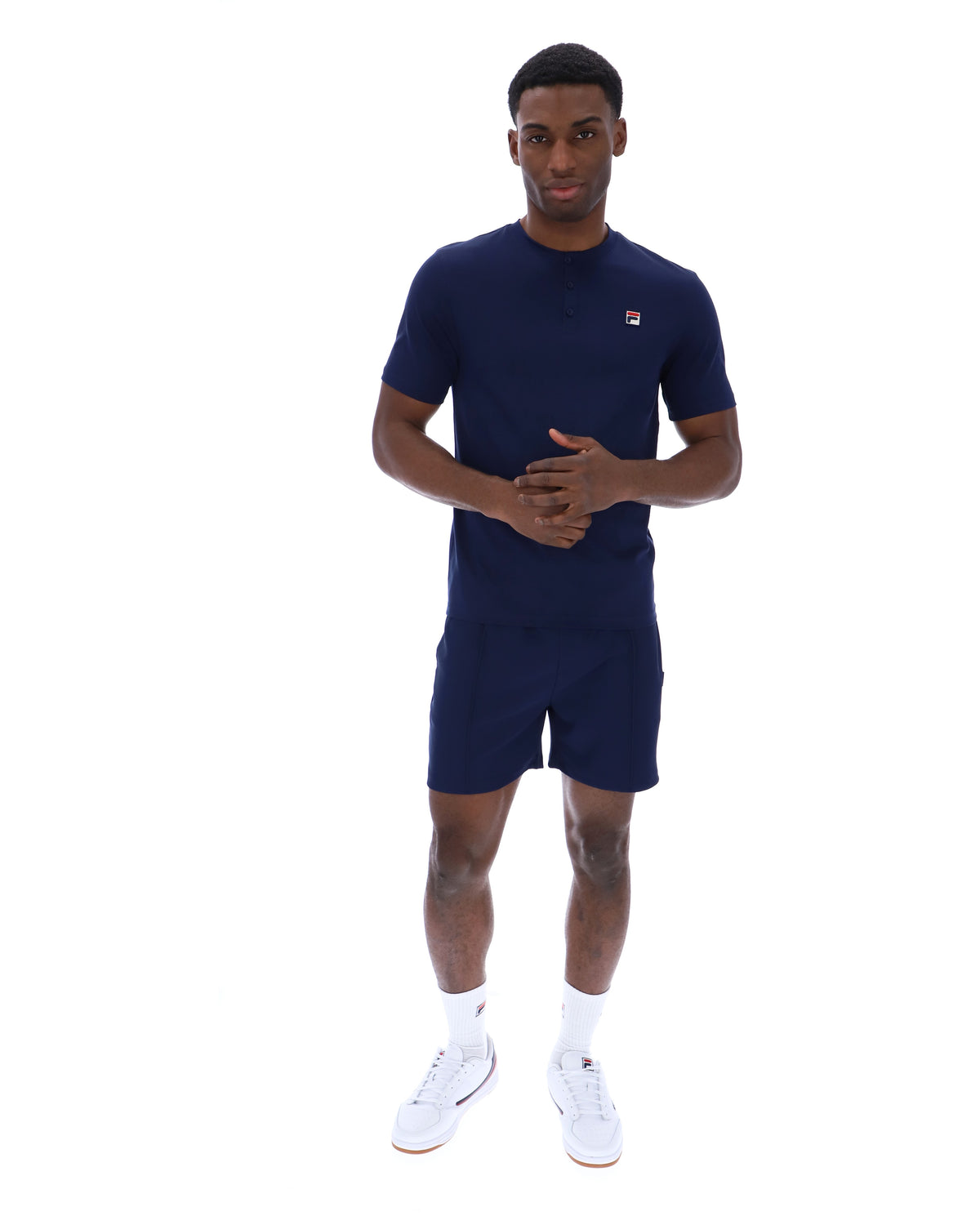Man wearing a navy blue t-shirt and shorts set with a logo on a white background