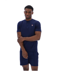 Man wearing a navy blue outfit with a logo on a white background