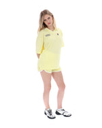 Woman wearing a yellow outfit with a logo on a white background