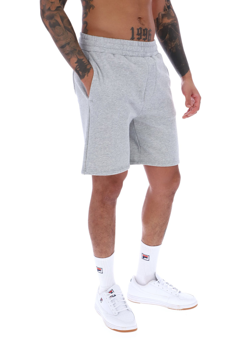 A male model wearing grey Vico Fleece short by FILA, with a relaxed fit and side pockets, in a light grey marl colour.