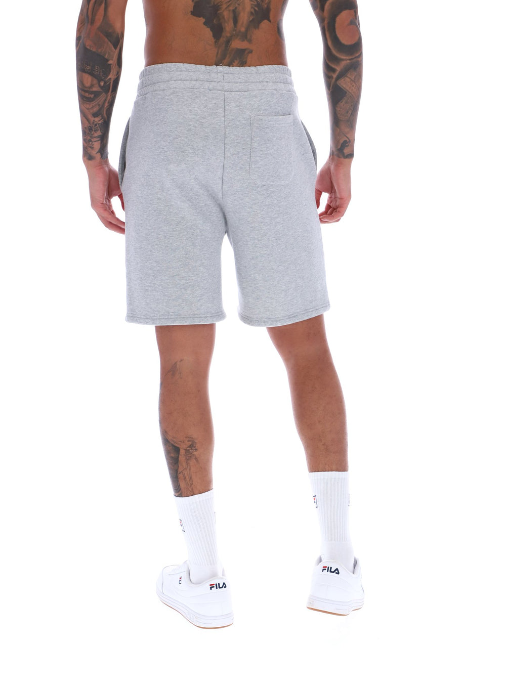 A male model wearing grey Vico Fleece short by FILA, with a relaxed fit and side pockets, in a light grey marl colour.