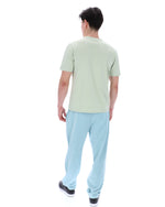 Person wearing a light green t-shirt and light blue pants on a white background