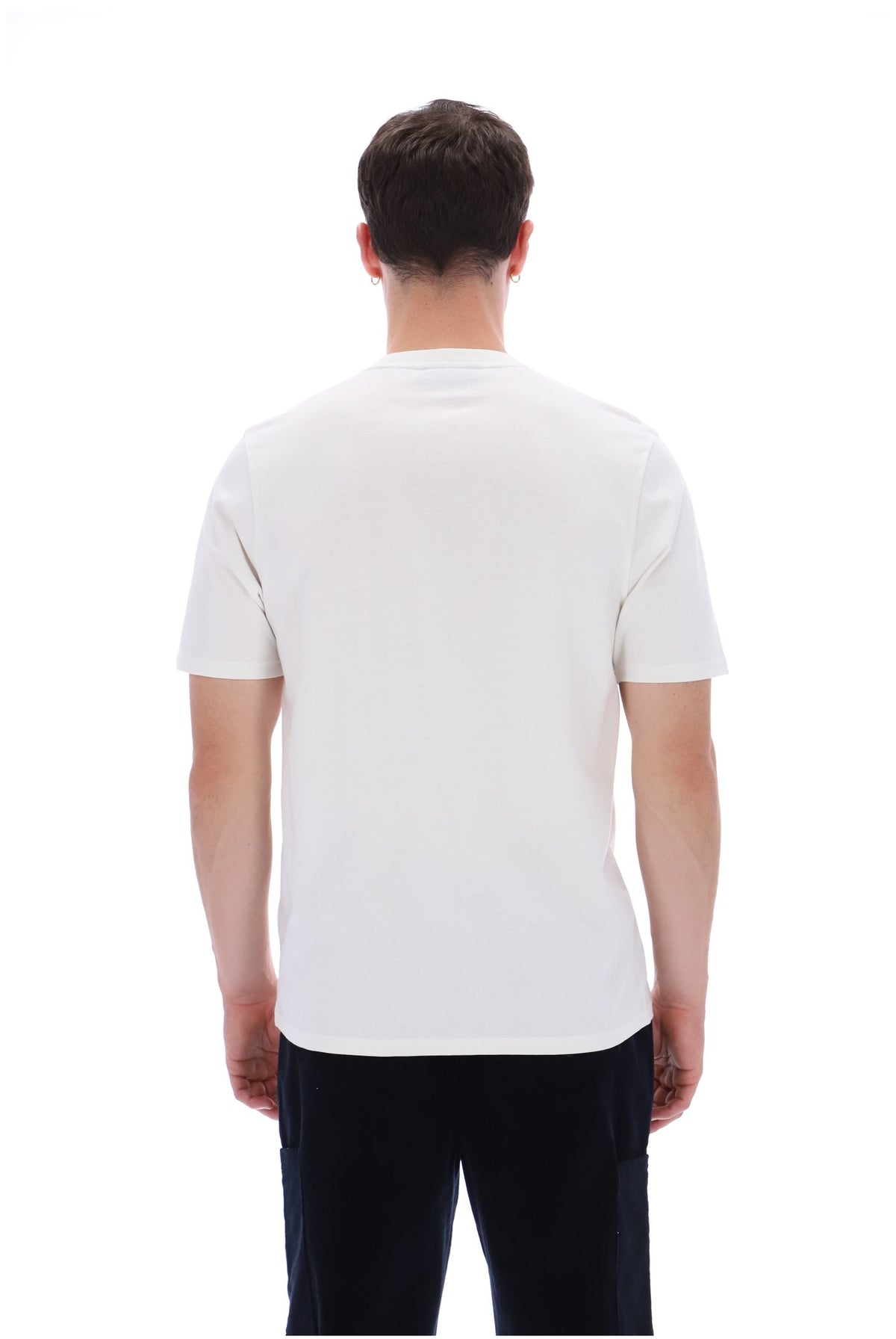 A man viewed from behind wearing a plain white short-sleeve crewneck t-shirt and dark pants, set against a solid white background.