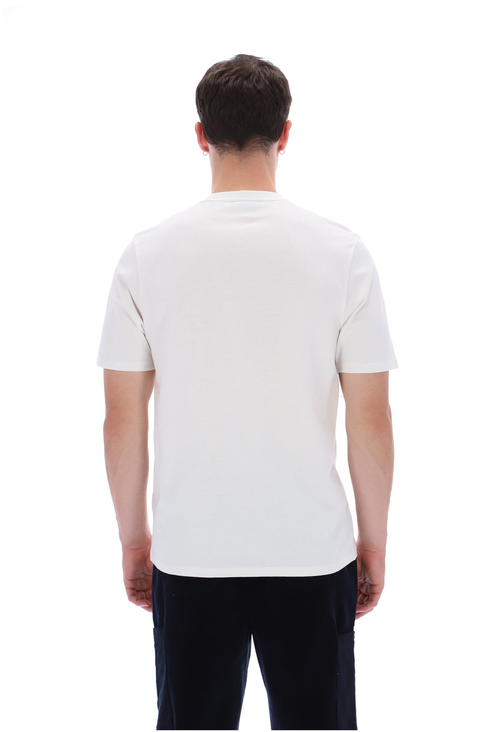 A man viewed from behind wearing a plain white short-sleeve crewneck t-shirt and dark pants, set against a solid white background.